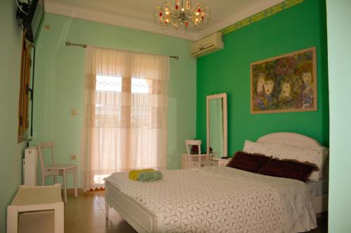 a bedroom with a bed and a green wall at Aethrio Guesthouse in Souvala