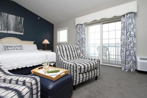a bedroom with a bed and a chair and a window at Bay Pointe Inn in Orangeville