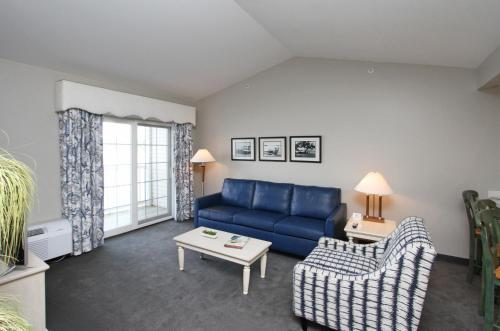 a living room with a blue couch and a table at Bay Pointe Inn in Orangeville