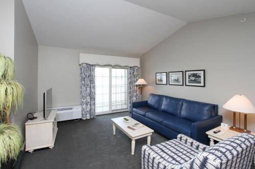 a living room with a blue couch and a table at Bay Pointe Inn in Orangeville