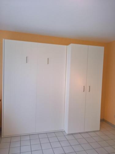 two white cabinets in a room with a ceiling at Studio Havenzicht in Nieuwpoort