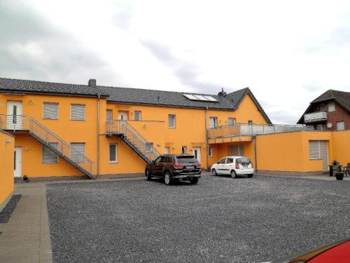 two cars parked in a parking lot in front of a building at Ferienwohnung Anke - Apartment 3c in Heinsberg