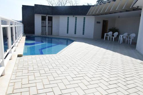 uma piscina ao lado de uma casa em Bevile Hotel em Cataguases