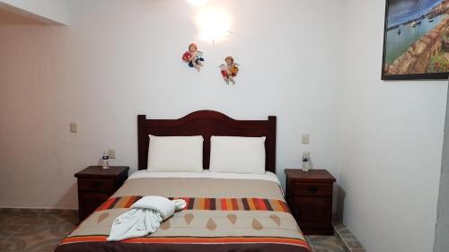 a bedroom with a bed with two nightstands and avertisement at El Jardín Del Edén in Tequisquiapan