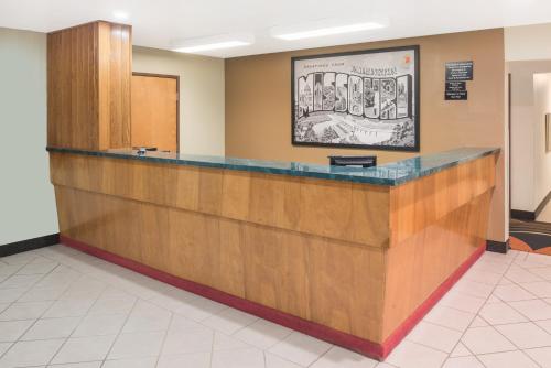 a lobby with a large wooden counter in a building at Super 8 by Wyndham Farmington in Farmington