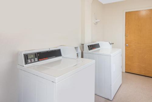 a kitchen with a microwave and a washer and dryer at Super 8 by Wyndham Farmington in Farmington