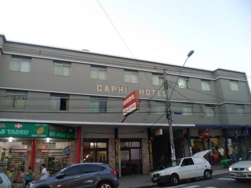 un gran edificio con coches estacionados frente a él en Hotel Capri, en Três Corações