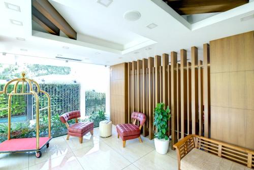 a waiting room with red chairs and a swing at Sidra Pristine Hotel and Portico Halls in Cochin