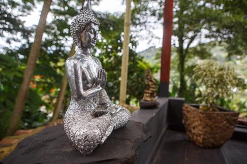 a statue of a woman sitting on a wall at The Secret Buddha in Medellín