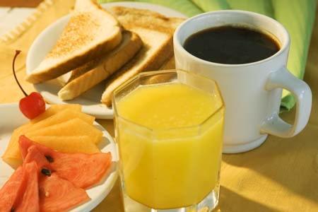 a table with a plate of fruit and a cup of coffee at Hotel Diaguitas Illapel in Illapel