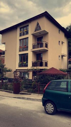 a green car parked in front of a building at Guest Rooms Profirov in Zlatograd