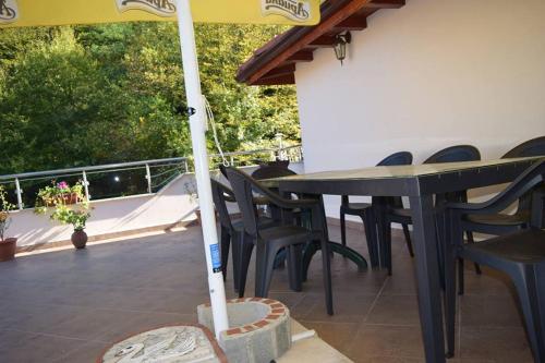 a patio with a table and chairs and an umbrella at Guest Rooms Profirov in Zlatograd