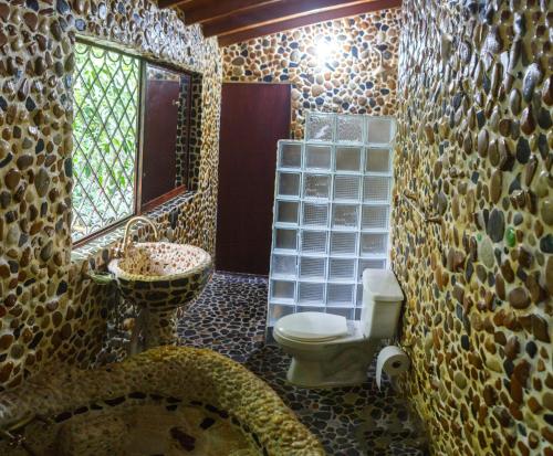 a bathroom with a toilet and a sink and a mirror at The Secret Buddha in Medellín