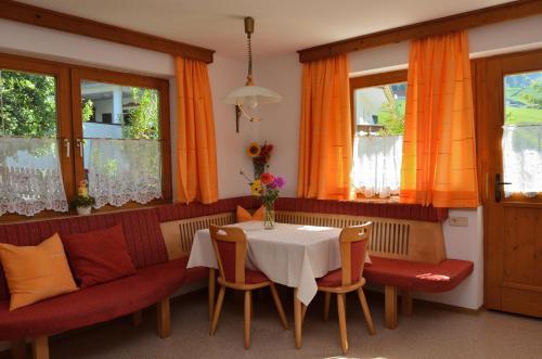comedor con mesa, sillas y ventanas en Ferienwohnung Haas Maria, en Neustift im Stubaital