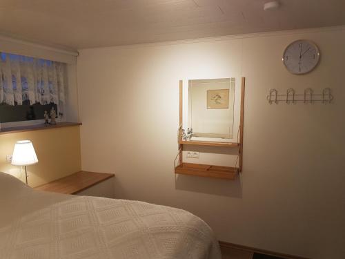 a bedroom with a bed and a clock on the wall at Holiday Guesthouse in Stykkishólmur