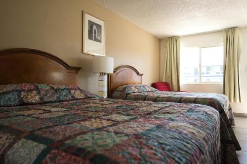 a hotel room with two beds and a window at Stardust Motel in Redding