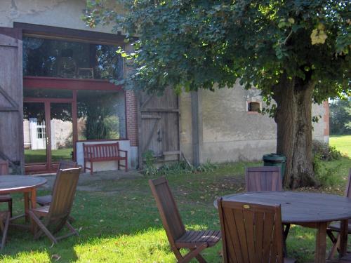 a group of tables and chairs under a tree at Chambres d'Hôtes Domaine du Bourg in Gannay-sur-Loire
