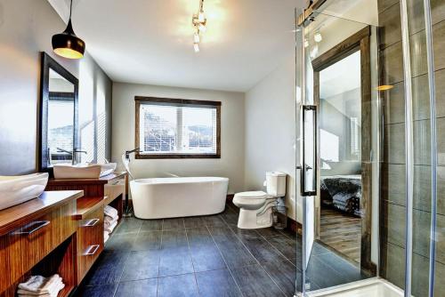 Un baño con bañera, inodoro y lavabo. en Chalet 42 Chemin Blanc by Les Chalets Alpins, en Stoneham