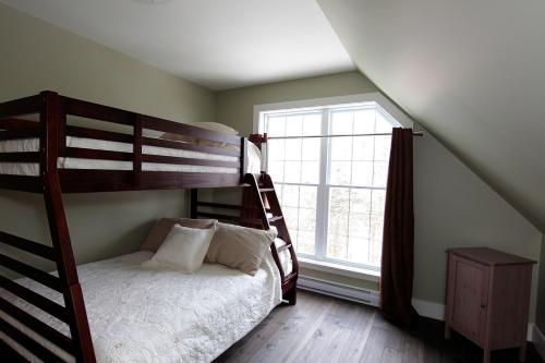 - une chambre avec des lits superposés et une fenêtre dans l'établissement Chalet 9028 Chemin des Alpages by Les Chalets Alpins, à Stoneham
