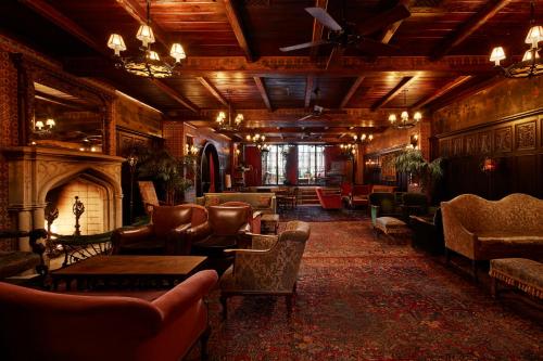 a living room with a fireplace and couches and chairs at The Bowery Hotel in New York