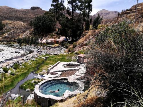 a swimming pool in the middle of a river at Aranwa Pueblito Encantado del Colca in Coporaque