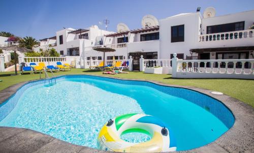 een zwembad met een strandbal voor een huis bij Casa La Ola in Puerto del Carmen