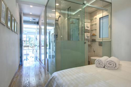um quarto com um chuveiro e uma cama com duas toalhas em Frixos Acropolis Luxury Apartment em Atenas
