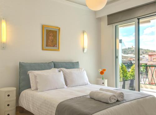 um quarto com uma cama grande e uma janela em Frixos Acropolis Luxury Apartment em Atenas