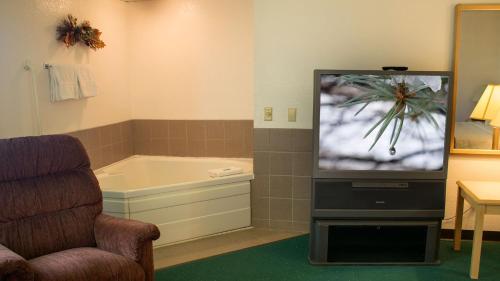 a living room with a tv and a bath tub at Odisha House of Rest in Shawano