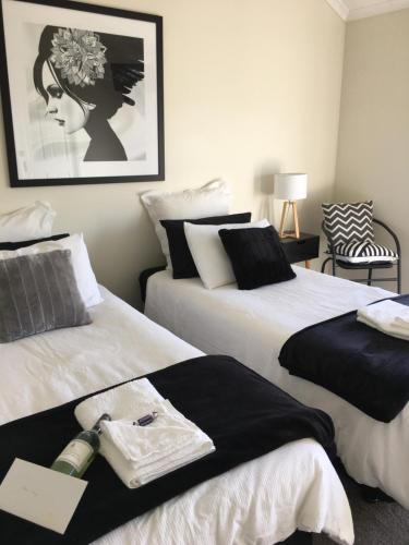 a bedroom with two beds with black and white at Rosewhite House in Myrtleford