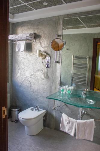 a bathroom with a sink and a toilet and a mirror at Hotel Gran Via in Zaragoza