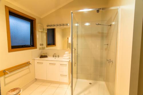 a bathroom with a shower and a sink at Freycinet Lodge in Coles Bay