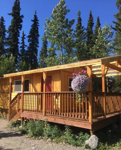 a wooden house with a flower pot on it at McKinley Creekside Cabins in McKinley Park