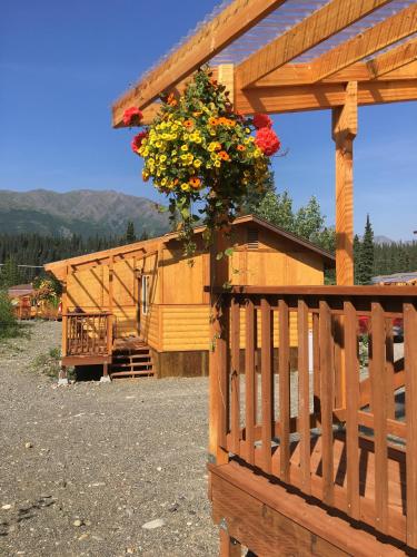 a wooden fence with a flower basket on it at McKinley Creekside Cabins in McKinley Park