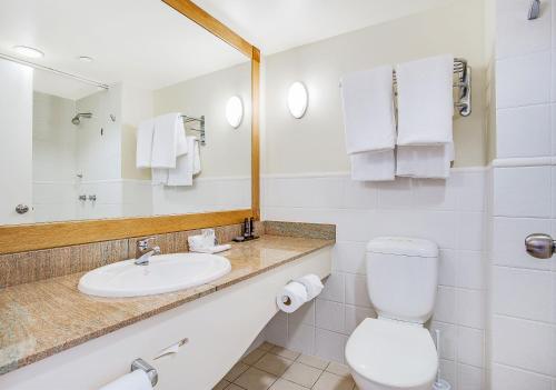 a bathroom with a sink and a toilet and a mirror at Mantra Twin Towns in Tweed Heads