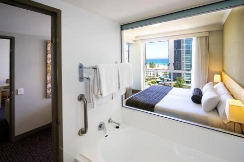 a hotel room with a bed and a large mirror at Mantra Twin Towns in Tweed Heads