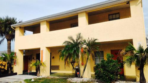 um edifício com palmeiras em frente em Sunset Inn- Fort Pierce, FL em Fort Pierce
