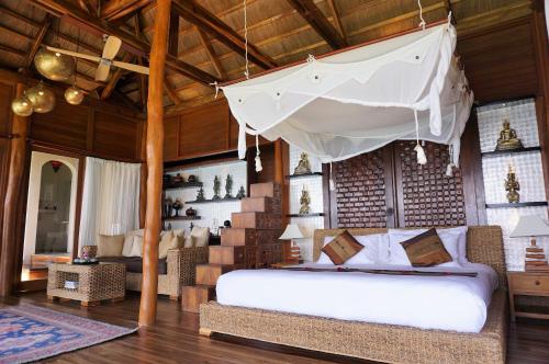um quarto com uma cama de dossel branco em Vellago Resort em El Nido