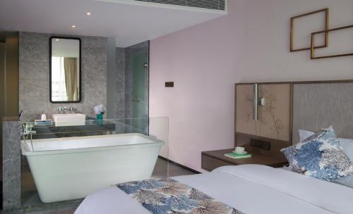 un bagno con vasca, lavandino e letto di Nuohuating Hotel a Gaoyao