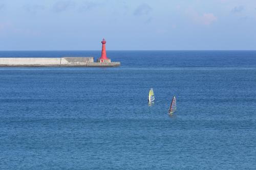 two sailboats in the water with a lighthouse in the background at Hualien S.E.A. B&B in Hualien City