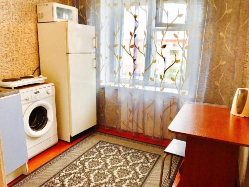 BelovoにあるApartments on Yubileinaya 4のキッチン(冷蔵庫、洗濯機付)