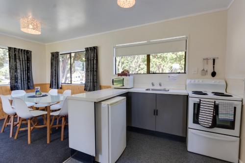 a kitchen and dining room with a table and chairs at Wellington TOP 10 Holiday Park in Lower Hutt