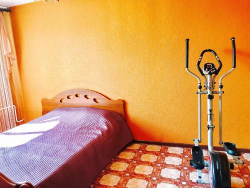 BelovoにあるАпартаменты на Советской 63のオレンジ色の壁のベッドルーム1室(ベッド1台付)