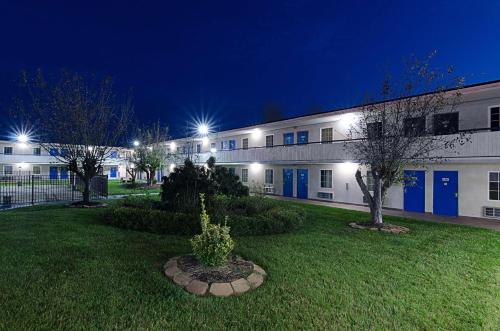 a building with blue doors and a courtyard at night at Motel 6-Staunton, VA in Staunton