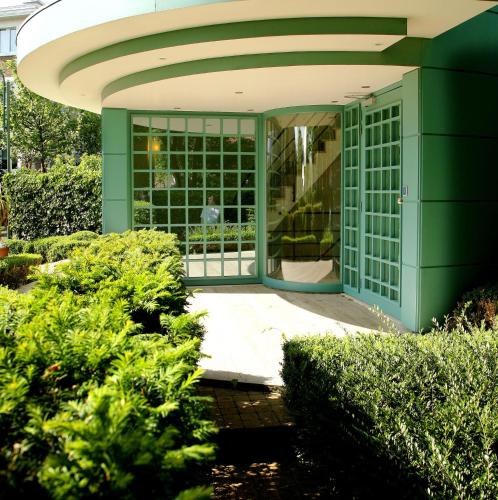 a green entrance to a house with bushes at Hotel Iris in De Panne