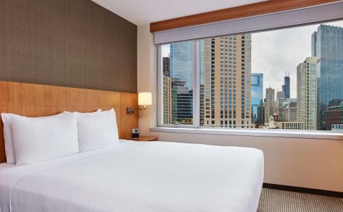 a bed in a hotel room with a large window at Hyatt Place Chicago River North in Chicago