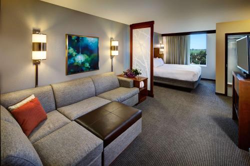 a hotel room with a couch and a bed at Hyatt Place UC Davis in Davis