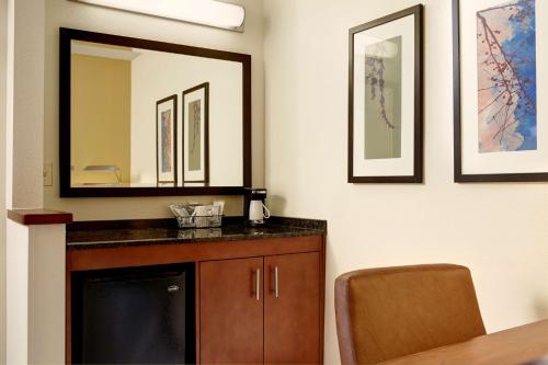 La salle de bains est pourvue d'un lavabo et d'un miroir. dans l'établissement Hyatt Place UC Davis, à Davis