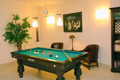 ein Zimmer mit einem Billardtisch in einem Zimmer mit Stühlen in der Unterkunft Hotel Iris in De Panne