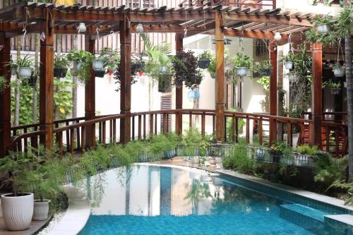 a swimming pool in a building with a wooden fence at Long Life Riverside Hotel in Hoi An